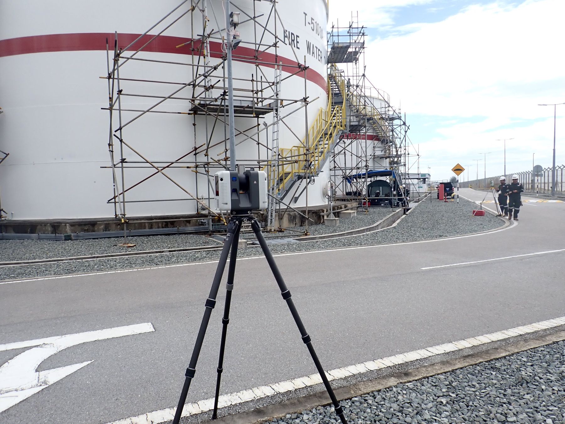 3D laser scanner on tripod in front of a firewater storage tank